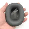 A hand holding a grey ear pad for headphones. Produktbild-Vorschau