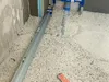 A construction site with a long leveling tool on the floor. Voir les images du produit