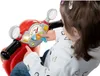 A young child is playing with a red toy Vespa scooter, interacting with its dashboard. Náhľad obrázku produktu