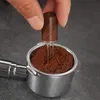 A hand is using a coffee distributor tool to evenly spread coffee grounds in a portafilter. Produktbild-Vorschau