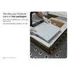 A person in gloves is packing a white furniture piece into a cardboard box with protective foam. Produktbild-Vorschau