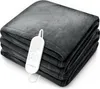 A folded gray plush heated blanket with a white remote control resting on top. Produktbild-Vorschau