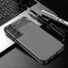 A smartphone case with a carbon fiber look is placed on a laptop keyboard next to two pens. Anteprima dell’immagine prodotto