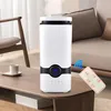 A white humidifier with a black accent band and a digital display sits on a wooden coffee table in a living room setting. A remote control with buttons is placed next to it, and a Wi-Fi symbol is overlaid on the image. Voir les images du produit