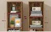Two identical narrow bookshelves side-by-side, showing different items on their shelves, with measurements indicated. Náhled obrázku produktu