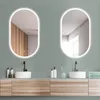 A modern bathroom vanity with two oval LED mirrors, sinks, and faucets. Anteprima dell’immagine prodotto