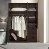 An open wardrobe with clothes hanging and folded on shelves and in drawers. A pillow and decorative pillows are also visible. Produktbild-Vorschau