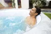 A man relaxing in an inflatable hot tub outdoors. Produktbild-Vorschau