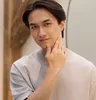 A man is touching his face in front of a blurred background. Náhled obrázku produktu