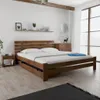 A bedroom scene with a wooden bed frame and nightstand. Náhled obrázku produktu
