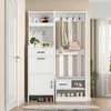 A white entryway organizer with coat hooks, shelves, drawers, and shoe storage is shown in a hallway next to a white door. Podgląd zdjęcia produktu