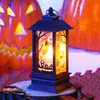 A Halloween-themed LED lantern sits on a wooden surface in front of carved pumpkins. Produktbild-Vorschau