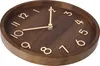 A close-up shot of a wooden wall clock with gold numbers and hands. Voir les images du produit