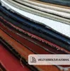 A close-up view of stacked leather swatches in various colors. Produktbild-Vorschau