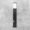 A black bollard light with a white top and a tan electrical outlet on a textured gray background. Produktbild-Vorschau