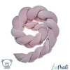 A pink braided baby nest is coiled on a white background. Náhled obrázku produktu