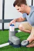 A man is kneeling on grass, inserting a filter into a pool pump. Produktbild-Vorschau