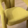 A close-up view of a yellow velvet chair seat and armrest, with a wooden floor in the background. Voir les images du produit