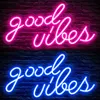 Two neon signs with the words "Good Vibes" are displayed on a brick wall. The top sign is pink, and the bottom sign is blue. Produktbild-Vorschau