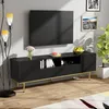 A modern living room scene featuring a black TV stand with gold legs, a television mounted on the wall, a floor lamp, and decorative items. Produktbild-Vorschau