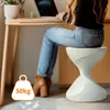 A woman is sitting at a desk and using a laptop, with a small stool next to her. Anteprima dell’immagine prodotto