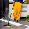 A person cleaning a floor with a steam mop. Voir les images du produit