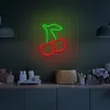 A neon cherry sign is displayed on a wall above a kitchen counter with various kitchen items. Produktbild-Vorschau