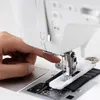 A close-up shot of a person's hand operating a sewing machine. Produktbild-Vorschau
