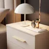 A bedside table with a lamp and perfume bottles. Produktbild-Vorschau