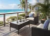 A patio or deck overlooking a beach and ocean. Náhľad obrázku produktu
