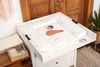 A baby changing pad with a fox design is placed on a white changing table, with a wooden door in the background. Podgląd zdjęcia produktu