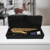 A saxophone case with a saxophone inside, placed on a white surface with a blurred background of a room. Podgląd zdjęcia produktu