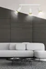 A modern living room with a grey sofa and a black marble coffee table, illuminated by a white and gold ceiling light. Podgląd zdjęcia produktu
