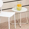 A white metal side table with a pitcher of lemonade and a glass of water on it, next to a white chair. Produktbild-Vorschau