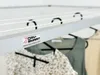 A close-up view of a ceiling-mounted clothes drying rack with clothes hanging on it. Voir les images du produit