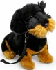 A plush toy dachshund sitting on a white background with a leash attached. Produktbild-Vorschau