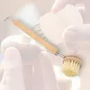 A close-up shot of a mushroom brush being used to clean a mushroom, with hands visible in the background. Produktbild-Vorschau