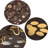 Close-up views of a brown dog mat with gold paw print and bone patterns, showing texture and water resistance. Náhled obrázku produktu