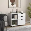 A white filing cabinet with drawers and shelves is placed next to a sofa in a room. Podgląd zdjęcia produktu