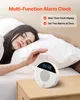 A woman sleeping in bed next to a white alarm clock on a nightstand. Náhľad obrázku produktu