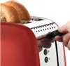 A close-up shot of a red toaster with two bagels inside. A hand is shown adjusting a dial on the side of the toaster. Náhľad obrázku produktu