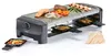 A raclette grill with food on top and in the small pans. Produktbild-Vorschau