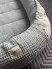 A close-up view of a baby nest with a waffle texture and a patterned inner lining. Produktbild-Vorschau