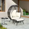 An outdoor patio scene with a rattan egg chair, ottoman, and side table. Anteprima dell’immagine prodotto