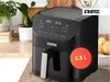 A black air fryer is shown on a kitchen counter with plants and potatoes in the background. A red circle with '5.5 L' is overlaid on the product. Produktbild-Vorschau
