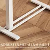 Close-up of the white metal frame of a desk on a wooden floor. Produktbild-Vorschau