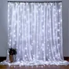 A white curtain with LED lights hanging down, with a small bouquet of flowers in a vase on the left. Náhled obrázku produktu
