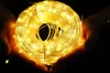 Hands holding a coiled string of warm white LED lights. Náhled obrázku produktu