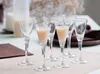 Six small glasses filled with a beige liquid are arranged on a table. Anteprima dell’immagine prodotto