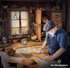 A woodworker polishing a wooden cutting board in his workshop. Produktbild-Vorschau